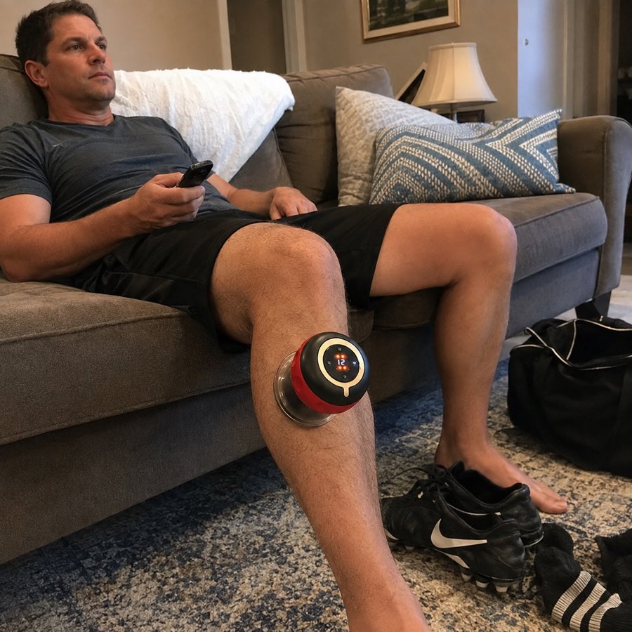 Recreational soccer player using Active Reset SmartCup on his calf while relaxing after a game